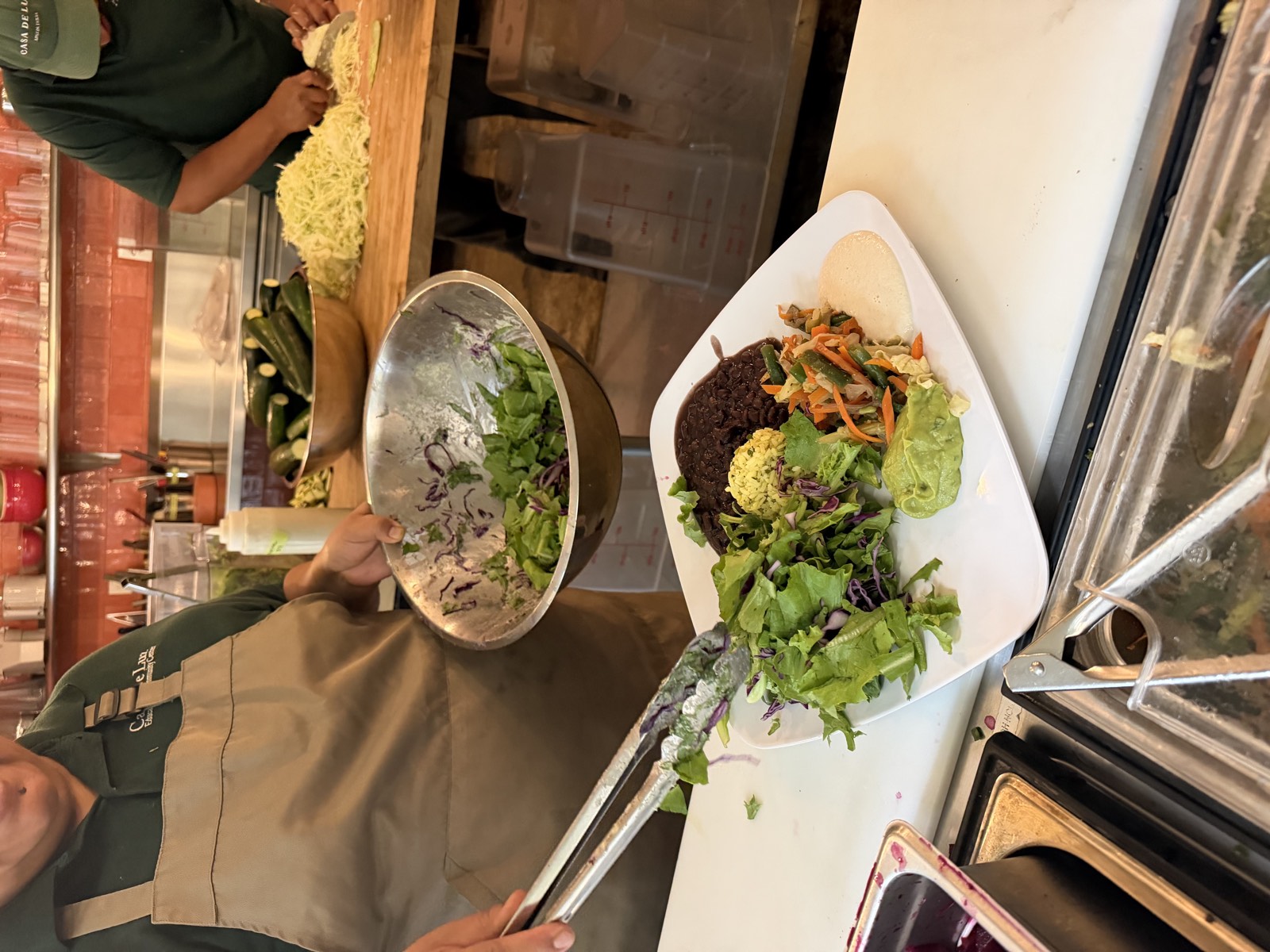 A Casa de Luz East cook plating a fresh whole-food meal by hand
