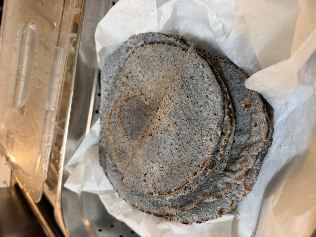 Stack of house-made blue-corn tortillas fresh off the griddle