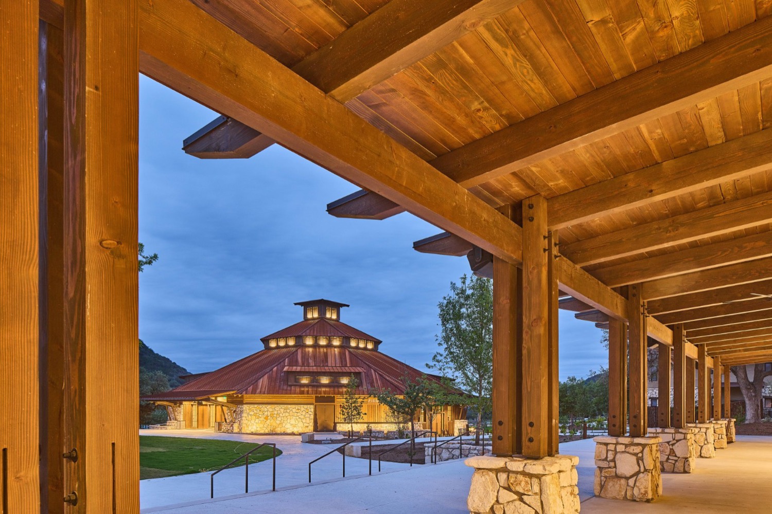 Fiesta Hall, the new indoor auditorium at LoneHollow Ranch, lit up at dusk