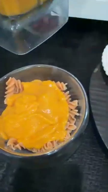 Whole-food cheese sauce poured over a bowl of pasta at Chef Mario's live demo
