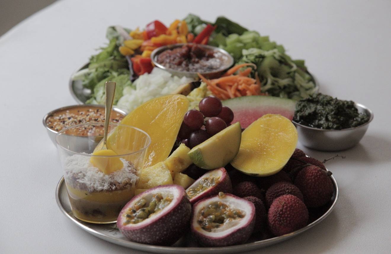 A platter of tropical fruit -- passion fruit halves, mango, lychees, grapes and coconut -- beside the salad bar