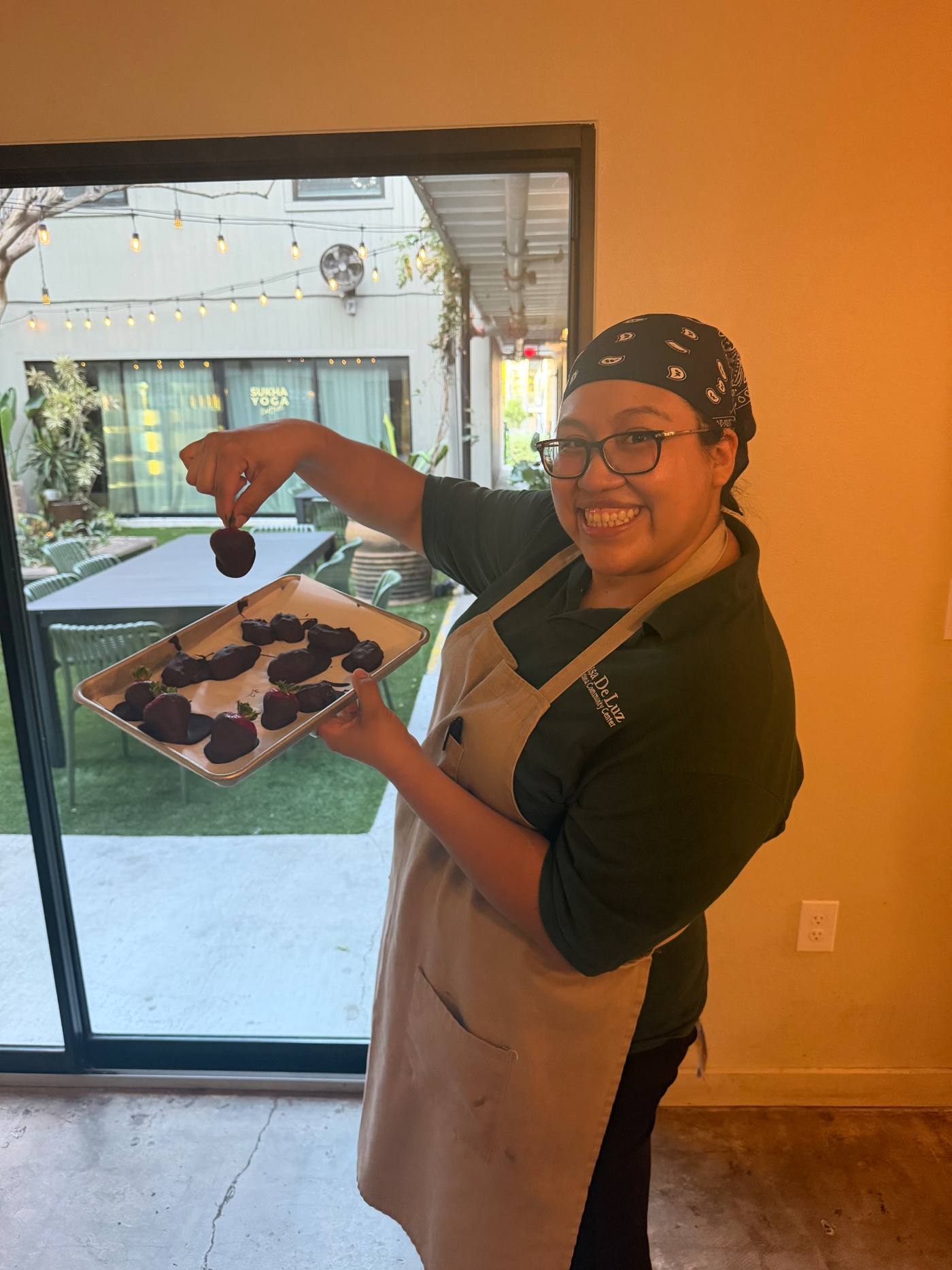 Sous chef Gabby Martinez holding a tray of chocolate-covered almond butter date truffles