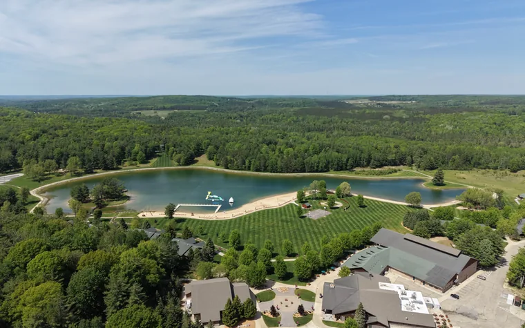Aerial view of Timber Wolf Lake, its beach and grounds in northern Michigan